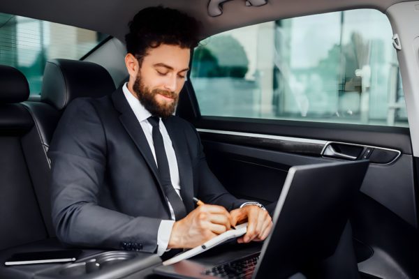 handsome-bearded-smiling-businessman-working-on-the-backseat-of-the-car-and-makes-notes-in-the-notebook-from-his-laptop-1024x683.remini-enhanced handsome-bearded-smiling-businessman-working-on-the-backseat-of-the-car-and-makes-notes-in-the-notebook-from-his-laptop-1024x683.remini-enhanced